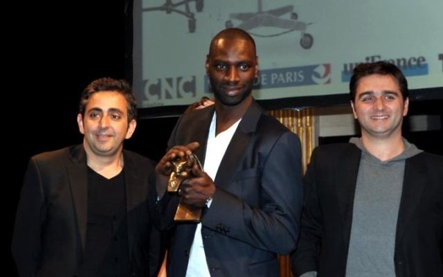 De gauche à droite : Éric Toledano, Omar Sy et Olivier Nakache à la cérémonie des Prix Lumières - 13 janvier 2012 (Crédit : Georges Biar/Wikimedia commons/CC BY SA 3.0) De gauche à droite : Éric Toledano, Omar Sy et Olivier Nakache à la cérémonie des Prix Lumières - 13 janvier 2012 (Crédit : Georges Biar/Wikimedia commons/CC BY SA 3.0)