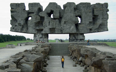 Mémorial à la "porte d'entrée" du camp. Le Pylône symbolique censé représenter les corps mutilés et se lit comme un signe yiddish abstrait (Crédit : domaine public)