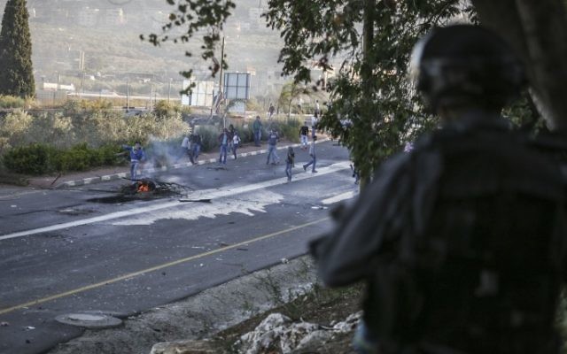 Les émeutiers jettent des pierres sur la police des frontières israélienne, à l'entrée du village arabe de Kfar Kanna dans le Nord d'Israël, le 8 novembre 2014. (Crédit : Hadas Parush / Flash90) Les émeutiers jettent des pierres sur la police des frontières israélienne, à l'entrée du village arabe de Kfar Kanna dans le Nord d'Israël, le 8 novembre 2014. (Crédit : Hadas Parush / Flash90)