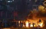 Jeunes Palestiniens jetant des pierres tsur des policiers israéliens devant le village de Kafr Kanna au nord d'Israël, le 9 novembre 2014 (Crédit : Flash90)