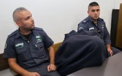 La garde-frontière accusé d'avoir tué un adolescent palestinien le 15 mai est emmené au tribunal de Jérusalem le 23 novembre 2014. (Crédit : Yonatan Sindel/Flash90)