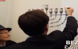 Le maire de Béziers Robert Ménard allumant les bougies de Hanoukka. (Capture d'écran : YouTube)