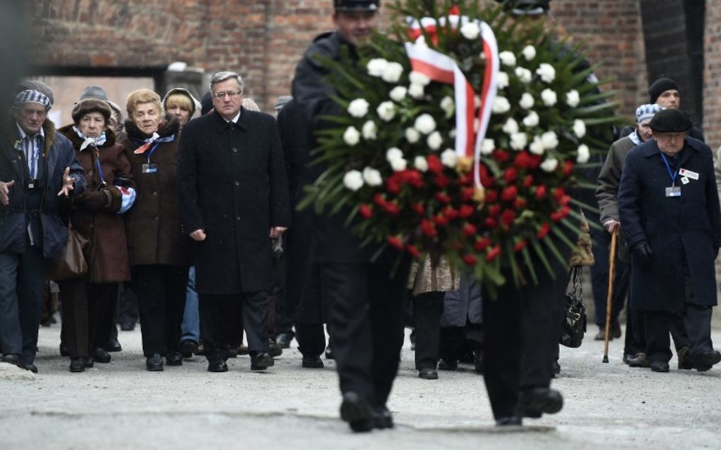 Le président polonais, Bronislaw Komorowski (au centre) et des survivants d'Auschwitz déposent une gerbe au mur de la mort de l'ancien camp de concentration d'Auschwitz le 27 janvier 2015 au mémorial d'Auschwitz-Birkenau à Oswiecim, Pologne. (Crédit : AFP PHOTO / ODD ANDERSEN)