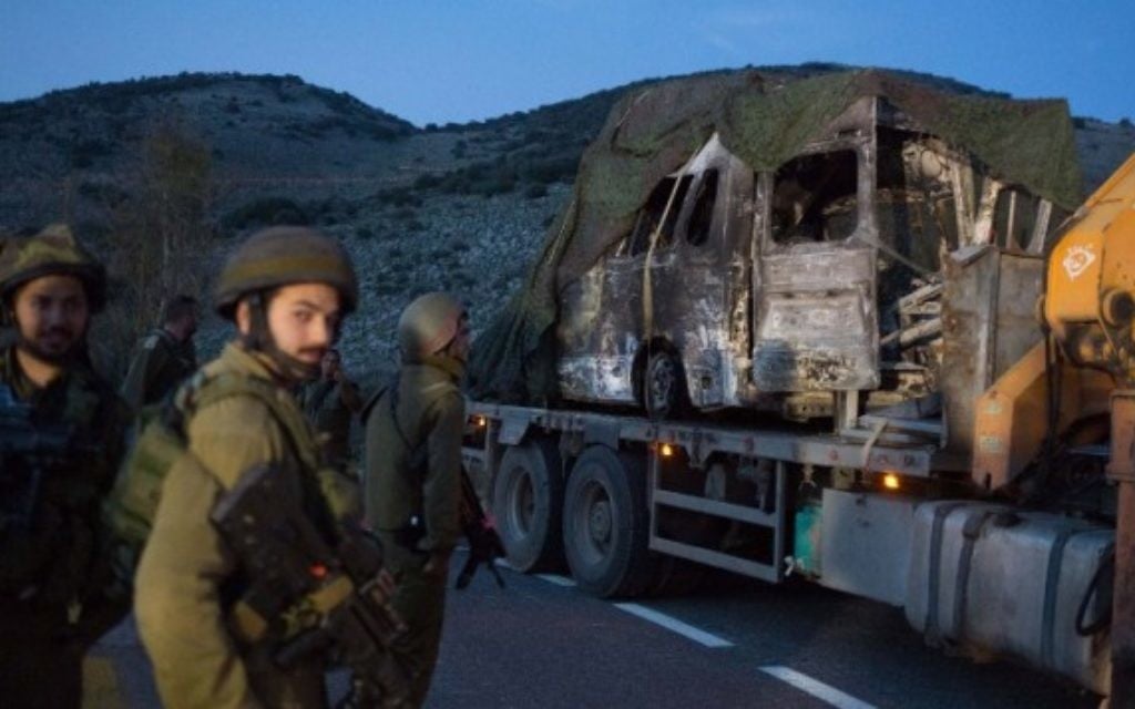 Des soldats israéliens regardent un véhicule brûlé près de Ghajar, après une attaque de missiles du Hezbollah le long de la frontière israélo-libanaise, le 28 janvier 2015. (Crédit : AFP/Menahem Kahana) Des soldats israéliens regardent un véhicule brûlé près de Ghajar, après une attaque de missiles du Hezbollah le long de la frontière israélo-libanaise, le 28 janvier 2015. (Crédit : AFP/Menahem Kahana)