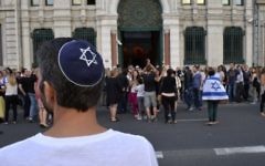 Illustration: Un homme avec une kippa regarde les gens prendre part à une manifestation organisée par le CRIF devant la synagogue de Lyon, le 31 Juillet 2014. (Crédit : Romain Lafabregue/AFP)