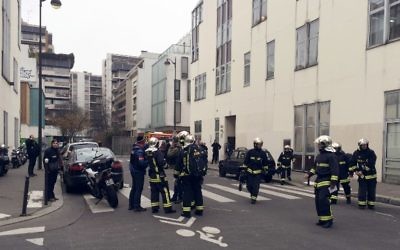 Des pompiers devant les locaux de Charlie Hebdo, le 7 janvier 2015. (Crédit : Philippe Dupeyrat/AFP)