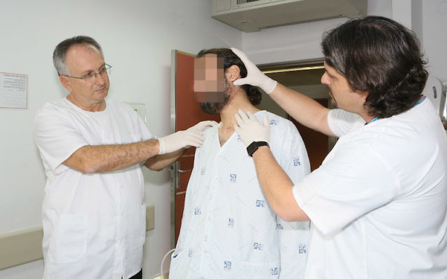 Le professeur Adi Rachmiel (à gauche) et Dr Yoav Leiser (à droite) avec un patient syrien (Crédit : RHCC) Le professeur Adi Rachmiel (à gauche) et Dr Yoav Leiser (à droite) avec un patient syrien (Crédit : RHCC)
