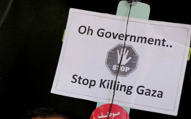 Une pancarte détenue par un des employés palestiniens de l'ancien gouvernement du Hamas (non représenté) lors d'une manifestation devant le siège du gouvernement d'union à Gaza, le 13 janvier 2015 (Crédit photo: AFP / MOHAMMED ABED)