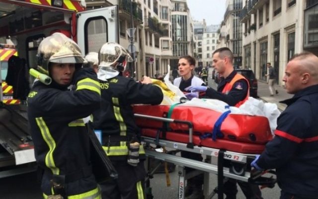 Des victimes emmenées d'urgence pour être soignées suite à l'attentat contre Charlie Hebdo (Crédit : AFP) Des victimes emmenées d'urgence pour être soignées suite à l'attentat contre Charlie Hebdo (Crédit : AFP)