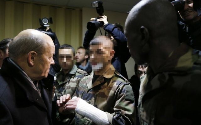 Le ministre français de la Défense, Jean-Yves Le Drian, s'entretenant avec les trois soldats attaqués par Moussa Coulibaly lors d'une patrouille à l'extérieur du centre communautaire juif de Nice le 3 février 2015 (Crédit : AFP/Valery Hache) Le ministre français de la Défense, Jean-Yves Le Drian, s'entretenant avec les trois soldats attaqués par Moussa Coulibaly lors d'une patrouille à l'extérieur du centre communautaire juif de Nice le 3 février 2015 (Crédit : AFP/Valery Hache)