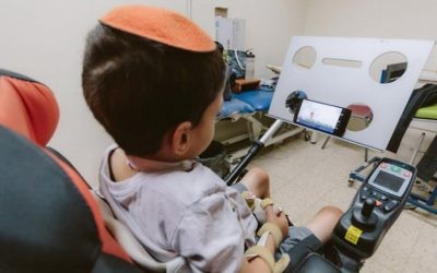 Un enfant handicapé en train d'utiliser un Sesame phone (Crédit : autorisation)