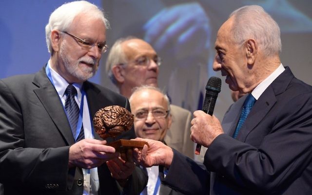 Dr. John Donoghue (à gauche) reçoit un chèque de d'un million de dollars remis par l'ancien président Shimon Peres au BrainTech le 5 octobre 2013 à Tel Aviv (Crédit : Chen Galili)