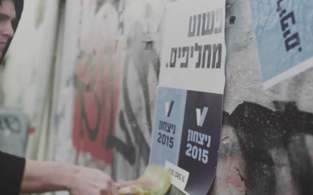 Des militants de V15 collant des affiches appelant au changement de Premier ministre (Crédit : YouTube/Victory2015) Des militants de V15 collant des affiches appelant au changement de Premier ministre (Crédit : YouTube/Victory2015)