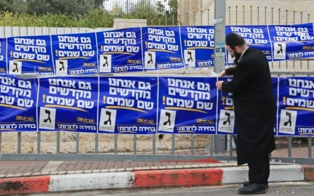 Un partisan ultra-orthodoxe de YaHadout HaTorah vu en train d'accrocher des affiches de campagne dans la ville de Beit Shemesh, le 17 mars, 2015. (Crédit : Yaakov Naumi / FLASH90) Un partisan ultra-orthodoxe de YaHadout HaTorah vu en train d'accrocher des affiches de campagne dans la ville de Beit Shemesh, le 17 mars, 2015. (Crédit : Yaakov Naumi / FLASH90)