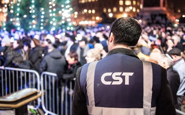 Un vigile du Community security Trust pendant une célébration de Hanoukka, à Londres, en 2014. (Crédit : Blake Ezra Photography via JTA)