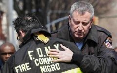 Le Maire de New York Bill de Blasio enlace le commandant des pompiers de New York Daniel Nigro  devant la maison en feu dans le quartier Midwood à Brooklyn le 21 mars 2015  (Crédit photo: Kena Betancur / Getty Images / AFP)