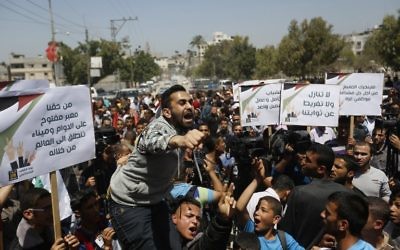 Des manifestants palestiniens défilent à Gaza, le 29 avril 2015. (Crédit : AFP)