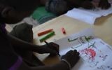 Un jeune réfugié nigérian dessine une scène d'attaque le 6 avril 2015 au cours d'une thérapie gérée par l'UNICEF dans le camp de réfugiés près de Baga Sola  (Crédit : AFP PHOTO / PHILIPPE DESMAZES)