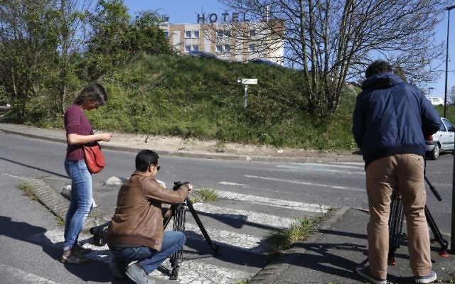 Des journalistes filment le site où le corps d'une femme avec trois blessures par balles a été retrouvé dans une voiture en feu à Villejuif, dans la banlieue sud de Paris, le 19 avril 2015. Les pompiers, prévenus par des passants qui ont vu la voiture en feu, sont arrivés sur les lieux et ont retrouvé le corps sans vie d'une femme âgée d'une trentaine d'année sur le siège passager à l'avant de la voiture en feu. La cause du décès n'a pas encore été établie. (Crédit : AFP PHOTO / FRANCOIS GUILLOT) Des journalistes filment le site où le corps d'une femme avec trois blessures par balles a été retrouvé dans une voiture en feu à Villejuif, dans la banlieue sud de Paris, le 19 avril 2015. Les pompiers, prévenus par des passants qui ont vu la voiture en feu, sont arrivés sur les lieux et ont retrouvé le corps sans vie d'une femme âgée d'une trentaine d'année sur le siège passager à l'avant de la voiture en feu. La cause du décès n'a pas encore été établie. (Crédit : AFP PHOTO / FRANCOIS GUILLOT)