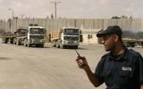 Un policier palestinien fidèle au Hamas monte la garde alors que des camions transportant des matériaux de construction entrent dans la bande de Gaza par Kerem Shalom, le 22 septembre 2013 (Crédit : Abed Rahim Khatib / Flash90)