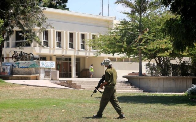 Un soldat israélien se promenant dans le kibboutz Nahal Oz temporairement abandonné dans le sud d'Israël, alors que les terroristes du Hamas à Gaza continuent de tirer des roquettes sur Israël au 34ème jours de l'opération Bordure protectrice, le 10 août 2014 (Crédit : Edi Israël / Flash90) Un soldat israélien se promenant dans le kibboutz Nahal Oz temporairement abandonné dans le sud d'Israël, alors que les terroristes du Hamas à Gaza continuent de tirer des roquettes sur Israël au 34ème jours de l'opération Bordure protectrice, le 10 août 2014 (Crédit : Edi Israël / Flash90)