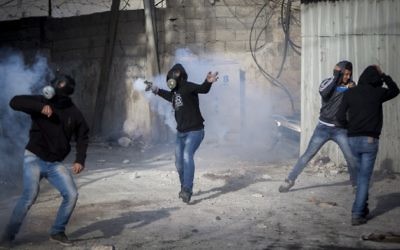 De jeunes Palestiniens jettent des pierres lors d'affrontements avec la police des frontières israélienne dans le camp de réfugiés de Shuafat, à Jérusalem, après les prières du vendredi 7 novembre 2014. (Crédit : Yonatan Sindel / Flash90)