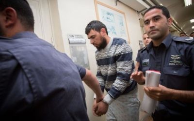 La police escorte l'Arabe israélien Khaled Koutineh lors d'une audience au tribunal de première instance, à Jérusalem, le 16 avril 2015 (Crédit : Miriam Alster / FLASH90)