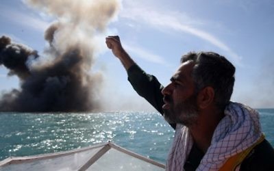 Un membre du corps d'élite iranien des Gardiens de la Révolution scande des slogans après l'attaque d'un navire de guerre pendant un exercice militaire dans le détroit d'Ormuz, au sud de l'Iran, le 25 février 2015. (Crédit : Hamed Jafarnejad/AFP/Fars News)