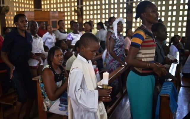 Un jeune tient une bougie lors d'un service de Pâques à la cathédrale catholique de Garissa le 5 avril 2015 après le meurtre de près de 150 personnes dans une attaque contre une université par les Shabab islamistes somaliens ciblant l'Université de Garissa. (Crédit : AFP / Carl De Souza) Un jeune tient une bougie lors d'un service de Pâques à la cathédrale catholique de Garissa le 5 avril 2015 après le meurtre de près de 150 personnes dans une attaque contre une université par les Shabab islamistes somaliens ciblant l'Université de Garissa. (Crédit : AFP / Carl De Souza)