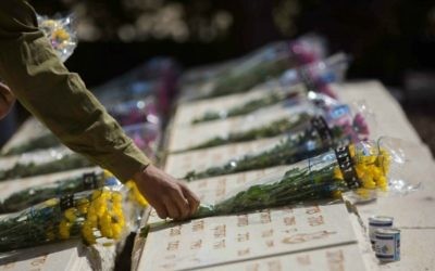 Un soldat de Tsahal dépose des fleurs sur la tombe d'un soldat tombé au combat au cours d'une cérémonie tenue au Mont des Oliviers, à Jérusalem, avant Yom Hazikaron, le 21 avril 2015. (Crédit photo: Yonatan Sindel / Flash90)