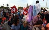 Les pèlerins juifs participent à la procession de la "Menara", une pyramide hexagonale représentant les cinq livres du prophète Moïse, en dehors de la synagogue de la Ghriba sur l'île touristique de Djerba, le 6 mai 2015. Le pèlerinage juif à la Ghriba synagogue a lieu sous une sécurité supplémentaire après le massacre du musée du Bardo et la mise en garde d'Israël de menaces terroristes existantes. (Crédit : AFP PHOTO / FETHI BELAID)