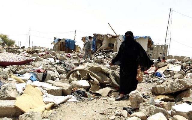 Une Yéménite au milieu des décombres des maisons détruites par une frappe aérienne saoudienne sur une zone résidentielle en avril 2015, dans la capitale Sanaa, le 18 mai 2015. (Crédit : Mohammed Huwais/AFP)