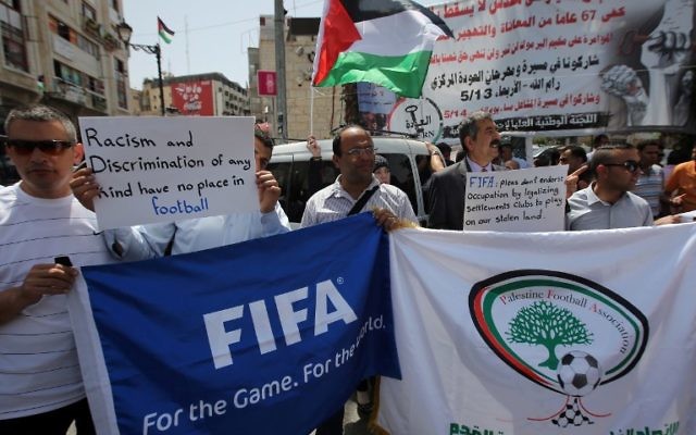 Des Palestiniens qui tiennent des bannières pendant une manifestation dans le centre de la ville de Ramallah en Cisjordanie, demandant l'expulsion d'Israël de l'organe mondial du football, la FIFA, le 19 mai 2015 (Crédit : AFP PHOTO / ABBAS MOMANI) Des Palestiniens qui tiennent des bannières pendant une manifestation dans le centre de la ville de Ramallah en Cisjordanie, demandant l'expulsion d'Israël de l'organe mondial du football, la FIFA, le 19 mai 2015 (Crédit : AFP PHOTO / ABBAS MOMANI)