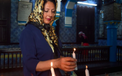 Une femme allume une bougie à la synagogue de la Ghriba en Tunisie (Crédit : AFP)