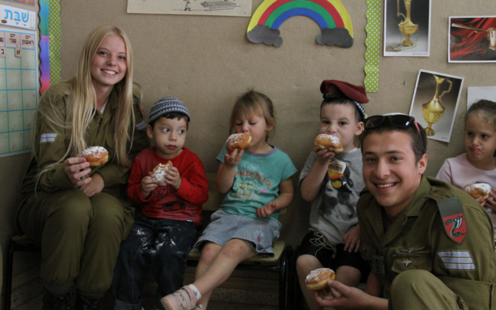 Des soldats qui envisagent  une conversion en visite dans un jardin d'enfants à Efrat, pour Hannukah, le 7 novembre 2013 (Crédit : Gershon Elinson /Flash 90)