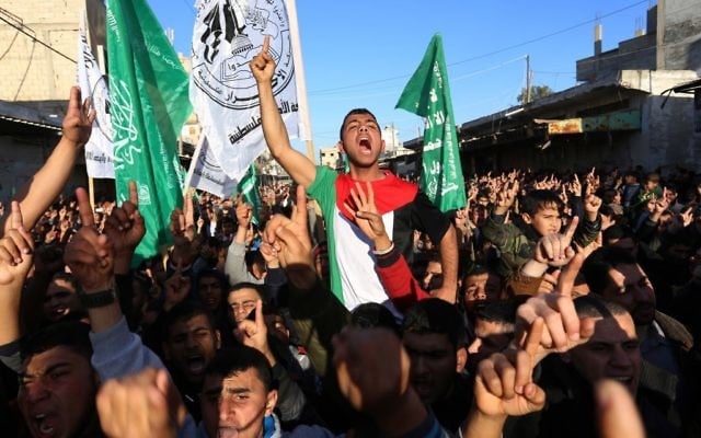 Des hommes palestiniens crient des slogans lors d'un rassemblement près de la frontière de Rafah, entre le sud de la bande de Gaza et l'Egypte le 5 février 2015. (Crédit : Abed Rahim Khatib / Flash90)