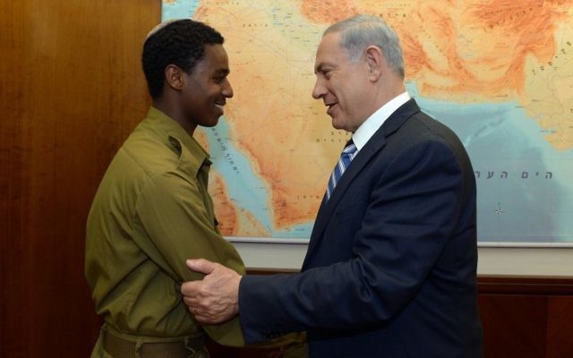 Le Premier ministre Benjamin Netanyahu rencontre Damas Pakada, le soldat éthiopien israélien qui a été agressé par des policiers, au bureau du Premier ministre, à Jérusalem, le 4 mai 2015 (Crédit : Haim Zach/GPO)