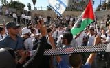 Des Palestiniens protestent tandis que des adolescents  juifs célèbrent la Journée de Jérusalem, Porte de Damas, dans la Vieille Ville de Jérusalem, 17 mai 2015. (Crédit : Nati Shohat / Flash90]