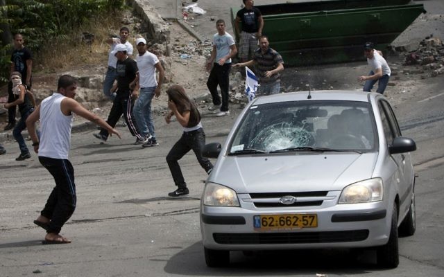 Des manifestants lançant des pierres sur une voiture dans le quartier de Silwan, à Jérusalem Est, en 2011. (Crédit : Yonatan Sindel/Flash90)