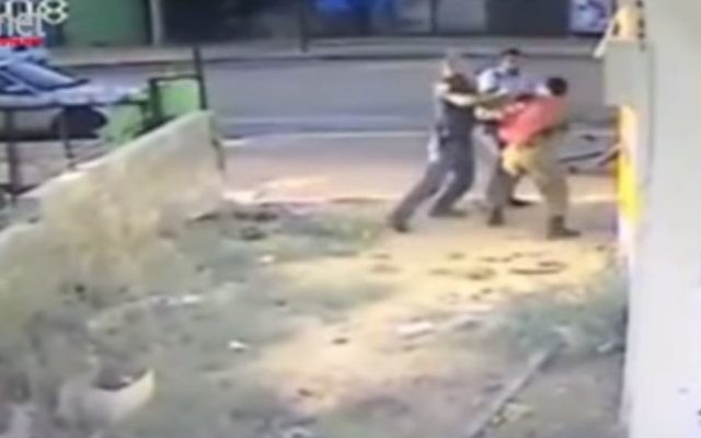 Des images de la vidéo montrant des policiers rouant de coups un soldat d'origine éthiopienne, Damas Pakada, qui a affirmé avoir été la cible d'une attaque raciste, en mai 2015. (Crédit : capture d'écran YouTube)