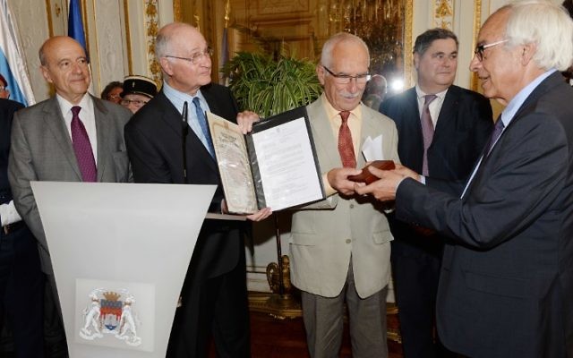 Yossi Gal (d) et Alain Juppé délivrent la médaille des Juste parmi les Nations à Jean-Pierre Fabre, fils de Suzon et Fernand Fabre, le 8 juin 2015 à Bordeaux. (Crédit : MEHDI FEDOUACH / AFP) Yossi Gal (d) et Alain Juppé délivrent la médaille des Juste parmi les Nations à Jean-Pierre Fabre, fils de Suzon et Fernand Fabre, le 8 juin 2015 à Bordeaux. (Crédit : MEHDI FEDOUACH / AFP)