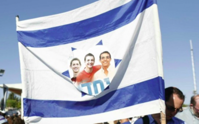 Drapeau israélien flanqué de l'image des trois adolescents assassinés et du mot hébreu « Yahad » (ensemble), lors de leur cérémonie funéraire conjointe, dans le cimetière de Modiin, le 1er juillet 2014. (Crédit : Yonatan Sindel / Flash90)