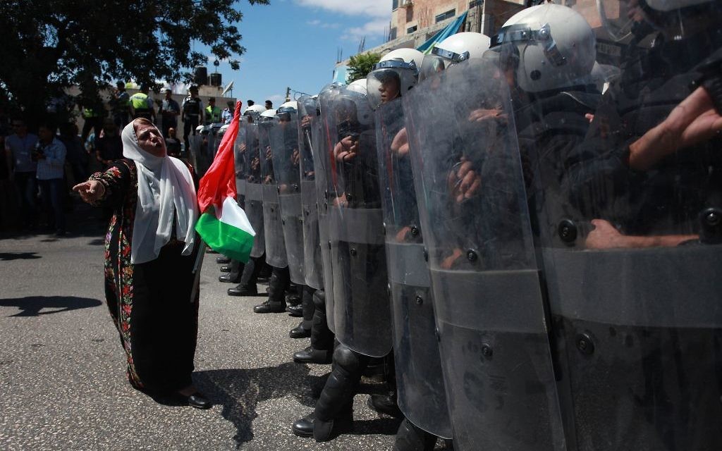 La police palestinienne en équipement anti-émeute empêche des partisans du Front Populaire pour la libération de la Palestine (FPLP) d'atteindre le siège du Président de l'AP, Mahmoud Abbas, dans la ville cisjordanienne de Ramallah, le 7 septembre 2013, lors d'une manifestation contre les négociations avec Israël. (Crédit : Issam Rimawi / Flash90)