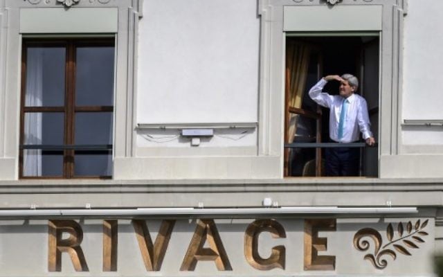 Le Secrétaire d'Etat américain John Kerry regarde par la fenêtre de sa chambre, à l'hôtel Beau-Rivage, lors d'une pause durant les négociations, à Lausanne, le 1er avril 2015. (Photo: AFP / Fabrice Coffrini)