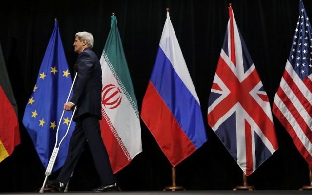 Le secrétaire d'Etat américain John Kerry quitte la scène après une photo de groupe avec les ministres des Affaires étrangères et des représentants de la Chine, l'Iran, la Grande-Bretagne, l'Allemagne, la France et de l'Union européenne au Centre international de Vienne, en Autriche, le 14 juillet 2015. (AFP / POOL / CARLOS BARRIA)