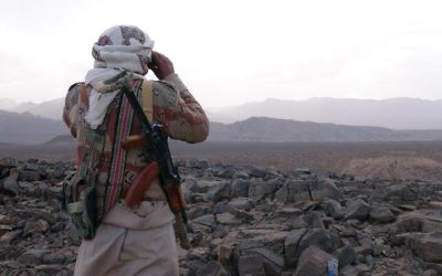 Un membre de la tribu yéménite armée du Comité de la Résistance Populaire soutenant les forces fidèles au président fugitif Abedrabbo Mansour Hadi qui regarde à travers des jumelles dans la région de Jaadan, à Marib, la province est de la capitale, Sanaa, le 9 mai 2015 (Crédit : AFP / STR)
