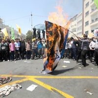 Des manifestants iraniens brûlent un drapeau israélien lors d'une manifestation pour marquer la journée internationale de Al Qods (Jérusalem) à Téhéran le 10 juillet 2015. (Crédit : AFP / ATTA KENARE)
