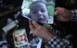 Un homme montre une photo de l'enfant palestinien Ali Saad Dawabsha de 18 mois qui est mort quand sa maison a été incendiée par des extrémistes juifs présumés dans le village cisjordanien de Duma le 31 juillet  2015 (Crédit photo:  Jaafar Ashtiyeh / AFP)