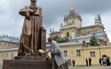 Une femme dépose des fleurs devant le monument pour l'Archevêque métropolitain de l'Eglise catholique grecque ukrainienne, Andriy Sheptytsky (1865-1944) après son inauguration pour le 150e anniversaire de sa naissance le 29 juillet 2015 dans le ville ukrainienne de Lviv (Crédit : AFP PHOTO / YURIY DYACHYSHYN)