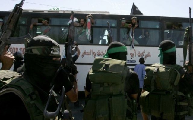 Des membres du Hamas surveillent la rue alors qu'un bus transportant des prisonniers palestiniens arrive dans le passage de Rafah limitrophe avec l'Egypte dans le sud de la bande de Gaza, suite à l'échange Shalit, le 18 octobre 2011 (Crédit : Abed Rahim Khatib / flash 90) Des membres du Hamas surveillent la rue alors qu'un bus transportant des prisonniers palestiniens arrive dans le passage de Rafah limitrophe avec l'Egypte dans le sud de la bande de Gaza, suite à l'échange Shalit, le 18 octobre 2011 (Crédit : Abed Rahim Khatib / flash 90)